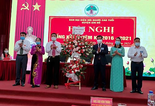 Đồng chí Bùi Văn Tuấn - Phó Bí thư Thường trực Huyện ủy tặng hoa chúc mừng Ban Đại diện Hội NCT huyện nhiệm kỳ 2021-2026